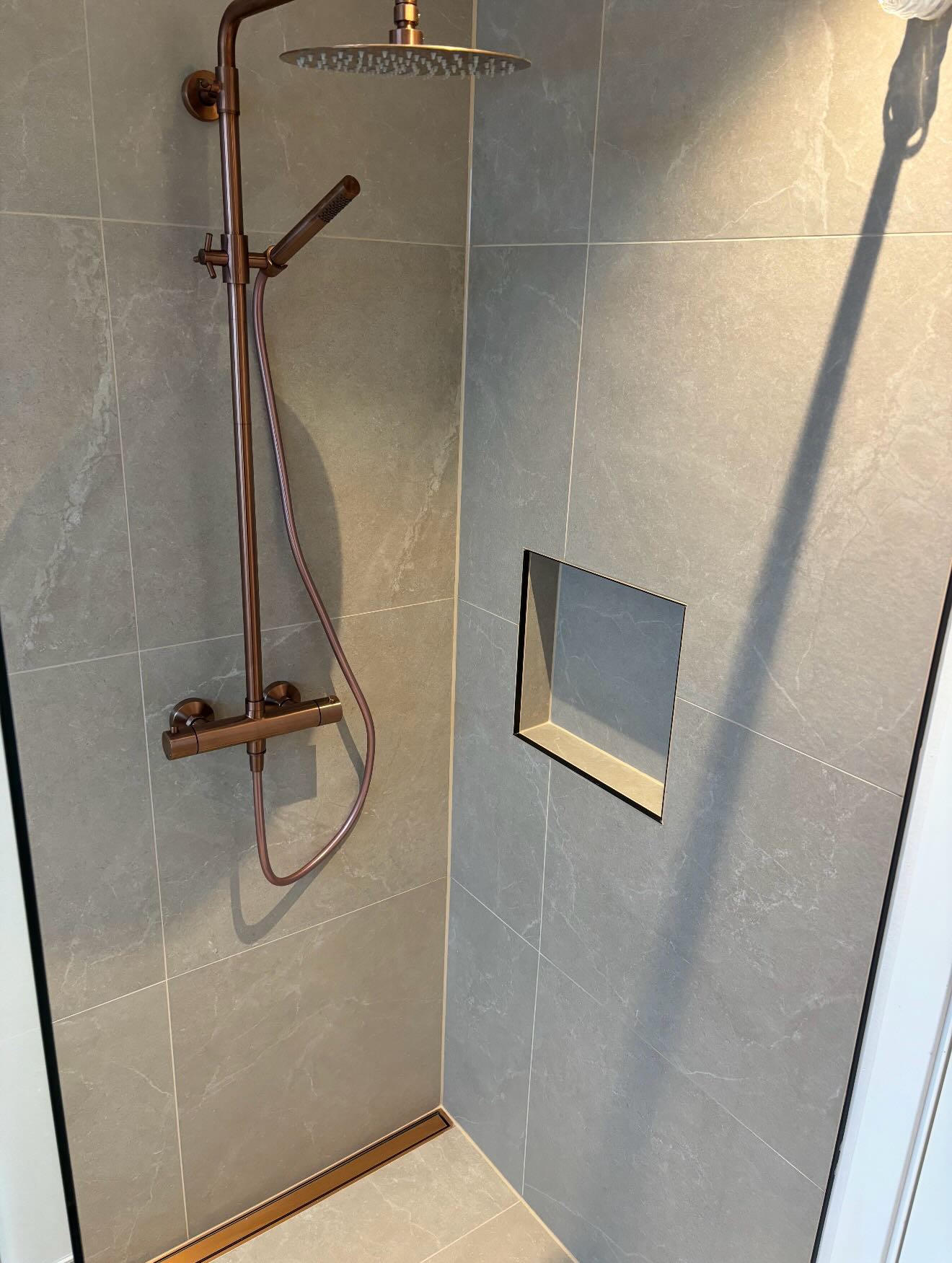 Nyt badeværelse med hvidt toilet og beige fliser